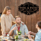 People enjoying a meal together outdoors with a 'Welcome to Our Pool & Patio' sign.