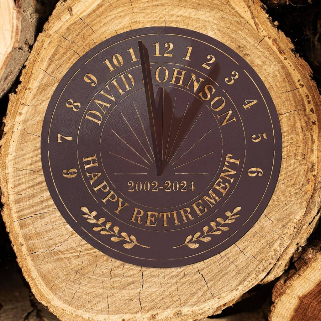 Personalized bronze metal sundial with custom text "DAVID JOHNSON HAPPY RETIREMENT 2002-2024" and a central gnomon, designed for outdoor garden decoration.