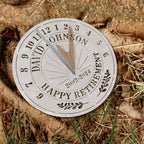 Personalized silver metal sundial with custom text "DAVID JOHNSON HAPPY RETIREMENT 2002-2024" and a central gnomon, designed for outdoor garden decoration.