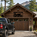Custom truck metal wall art mounted on a rustic cabin garage surrounded by pine trees and mountain scenery.