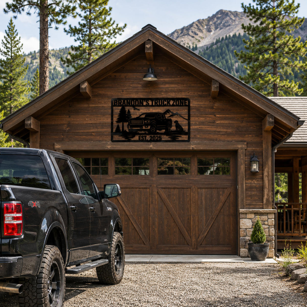 Custom truck metal wall art mounted on a rustic cabin garage surrounded by pine trees and mountain scenery.