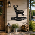 Custom black metal deer family sign displayed on a rustic lakeside cabin with forest views.