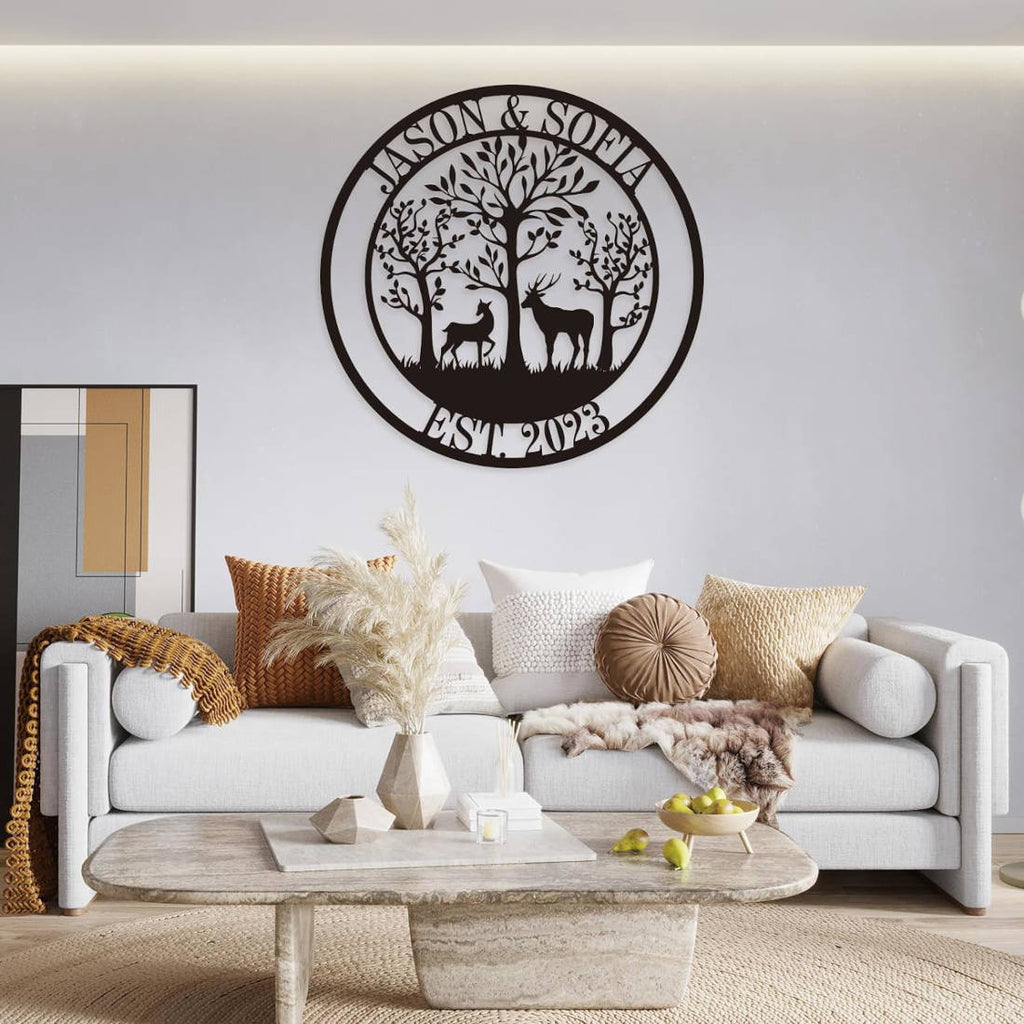 Customizable round black metal sign with a laser-cut design featuring a buck and a doe in a forest of trees. The top text reads "JASON & SOFIA" and the bottom text reads "EST. 2023".