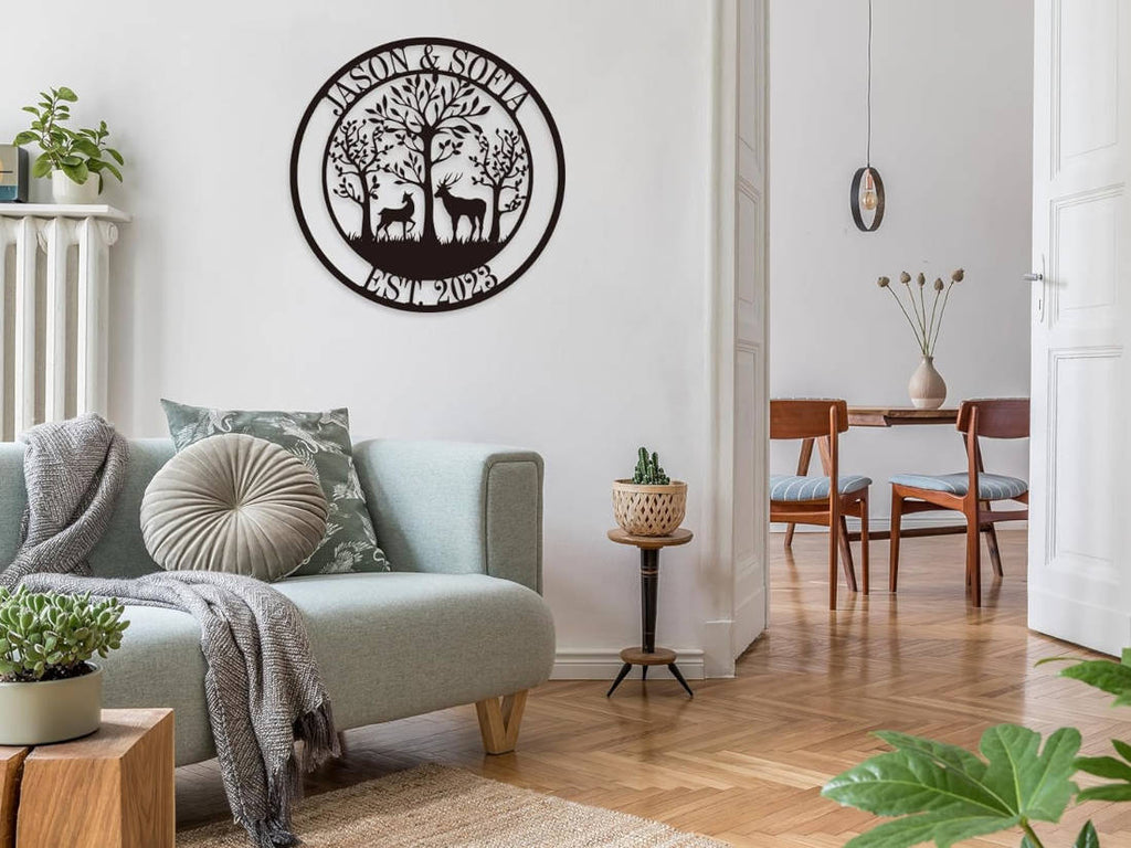 Customizable round black metal sign with a laser-cut design featuring a buck and a doe in a forest of trees. The top text reads "JASON & SOFIA" and the bottom text reads "EST. 2023".