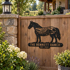 Custom horse ranch metal sign mounted on a wooden gate at a country home.