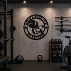 Black personalized home gym metal wall sign installed in an industrial-style fitness room.