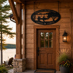 Personalized lake house metal sign hanging above a rustic cabin entrance with wooden wall and outdoor lighting