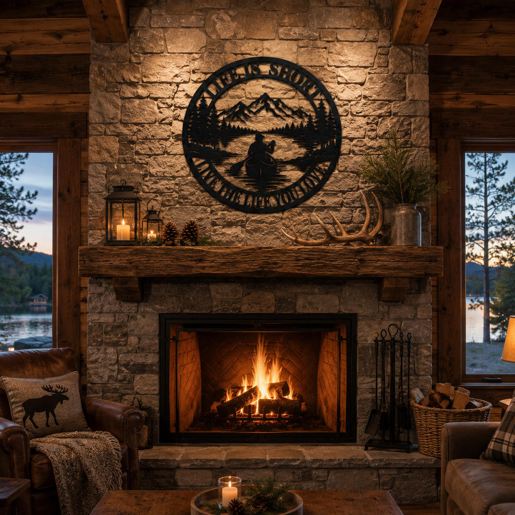 Round metal mountain wall art displayed above a rustic stone fireplace in a cozy cabin living room.