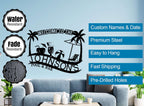 Customizable black metal sign with a tropical design, featuring palm trees, a beach umbrella, lounge chair, beach ball, and cocktails, with "Welcome to The Johnson's Pool & Bar" text.