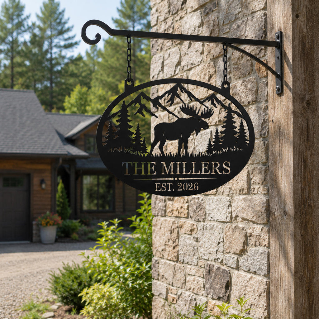 Personalized moose family metal sign hanging from a black metal bracket outside a rustic stone home.
