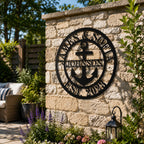 Custom outdoor metal family sign with anchor design mounted on a garden stone wall