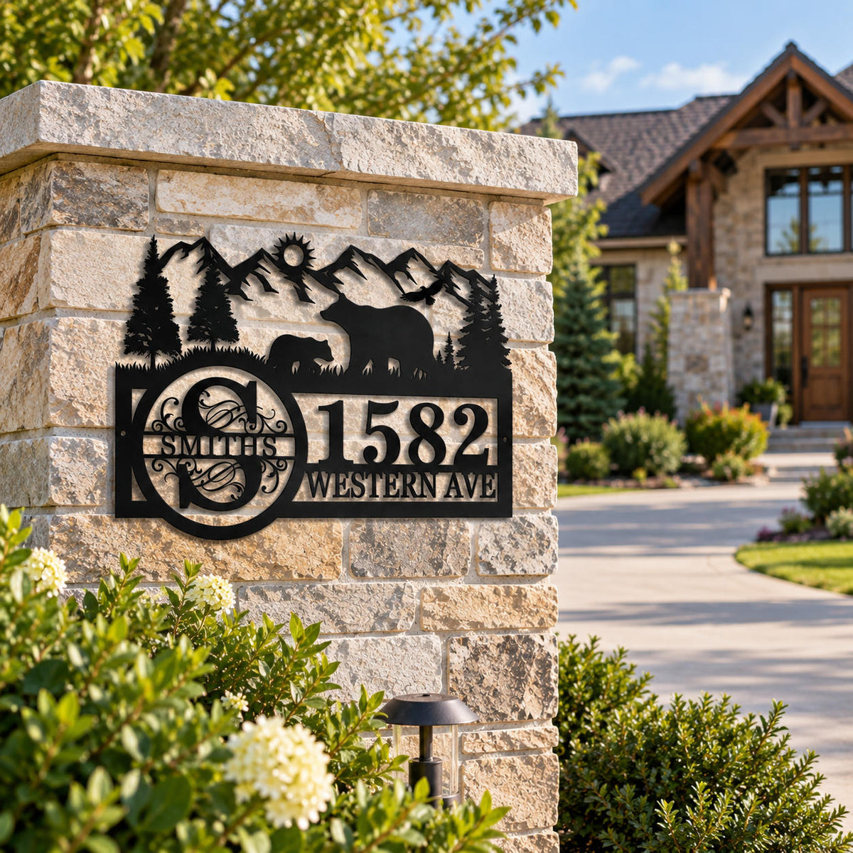 Personalized metal family address sign with bears and mountains displayed at a residential driveway entrance.