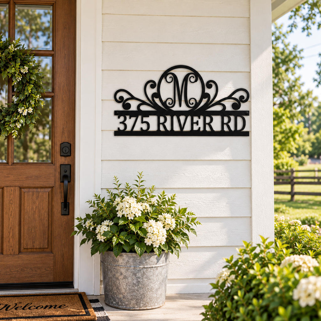 Personalized black metal monogram address sign displayed at a classic American farmhouse entrance.