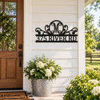 Personalized black metal monogram address sign displayed at a classic American farmhouse entrance.