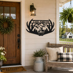 Personalized antler metal family sign displayed beside the front door of a rustic American farmhouse porch.