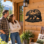 Couple admiring their personalized Anderson family bear metal sign mounted outside a rustic mountain cabin.