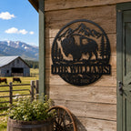 Personalized bison family name metal sign mounted on a rustic American ranch barn.