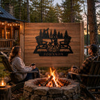Personalized metal campfire family name sign mounted on a rustic wooden fence beside a backyard fire pit at a woodland cabin.