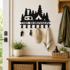 Personalized camping metal key holder mounted in a farmhouse entryway with keys, a cap, and a light towel.