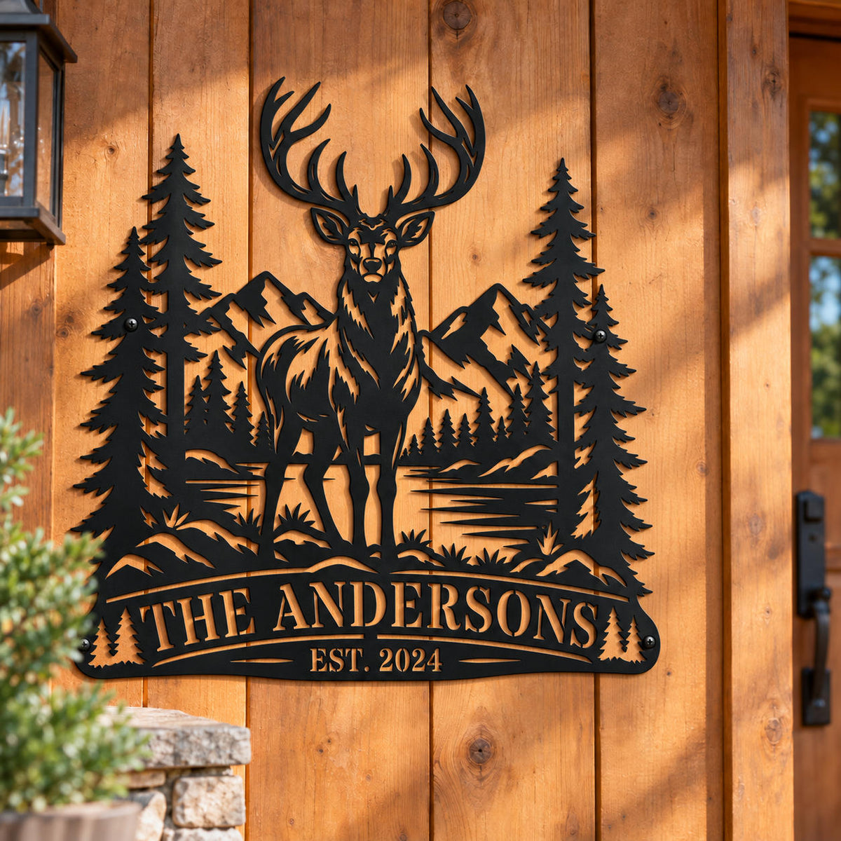 Personalized black elk metal sign mounted on a rustic wooden cabin exterior wall.