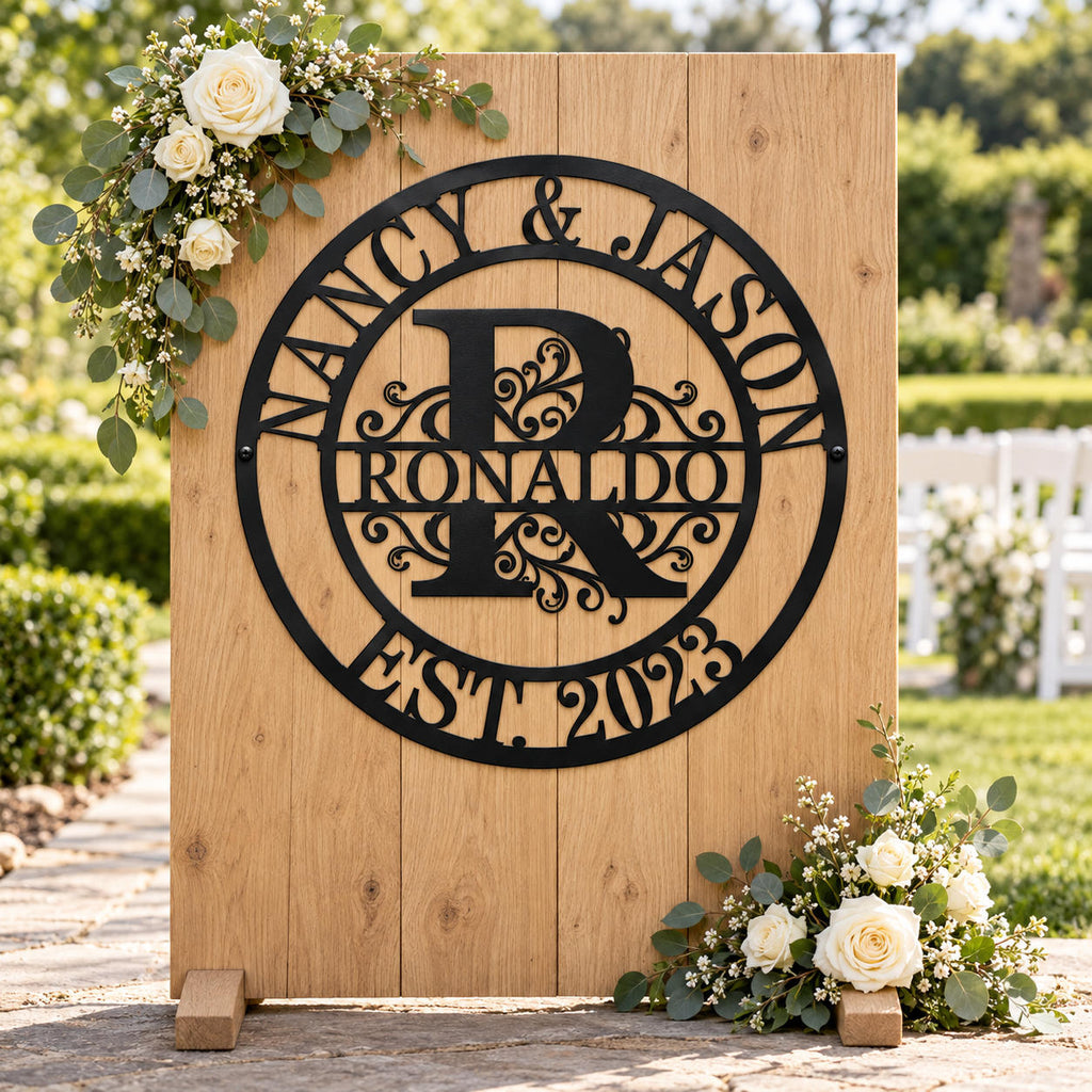 Personalized Nancy & Jason monogram sign on a wooden wedding welcome backdrop decorated with white roses and eucalyptus.
