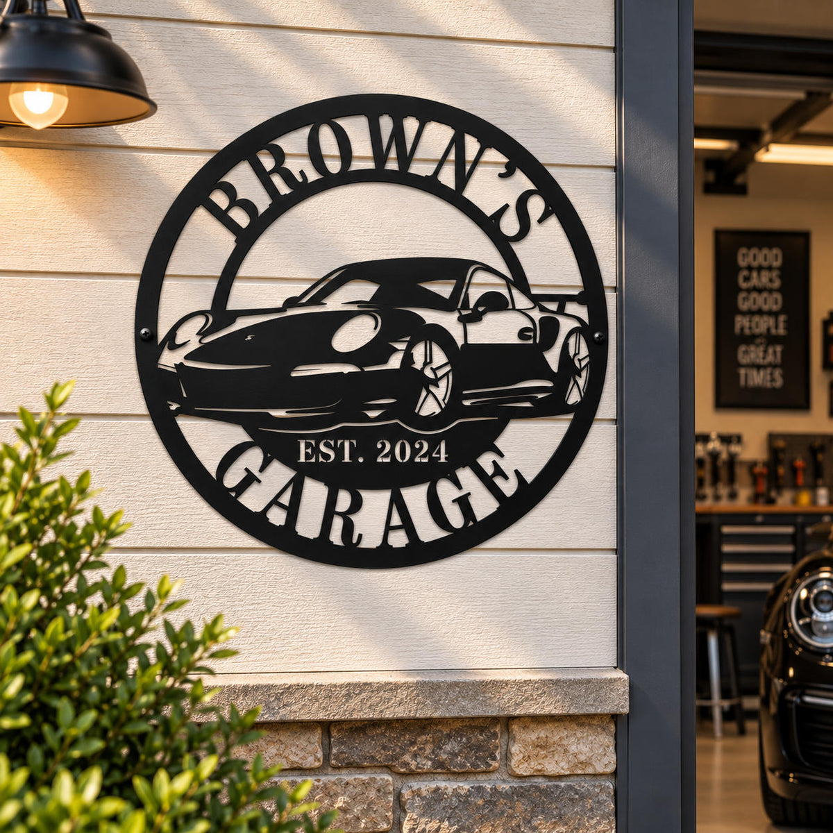 Personalized Brown's Garage metal sign displayed on an outdoor garage wall with a warm industrial light.