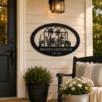 Personalized black greenhouse metal sign mounted beside a front door on a welcoming porch with plants and outdoor decor.