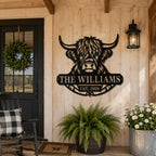 Personalized Highland cow metal family sign displayed on a rustic American farmhouse porch.
