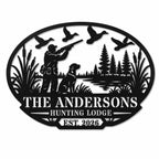 Personalized black metal hunting lodge sign featuring a hunter, dog, flying ducks, pine trees, and custom family name.