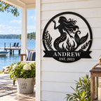 Personalized mermaid metal sign with family name and established year displayed at a lakeside home.