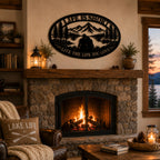 Personalized mountain lake couple metal wall art displayed above a cozy rustic stone fireplace.