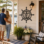 Personalized nautical metal family sign decorating a welcoming front porch, custom ship wheel wall art for coastal and lake house entryways.