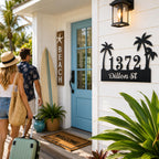 Personalized tropical palm tree metal address sign installed at the entrance of a beach-style Airbnb vacation rental.