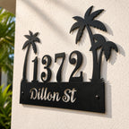 Close-up of a personalized tropical palm tree metal address sign showing hidden mounting holes in the palm tree crown and leaf for a clean installation.