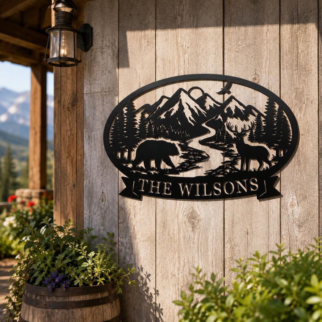 Personalized black metal wilderness family sign with bear, deer, mountains and custom last name displayed on a rustic cabin wall.