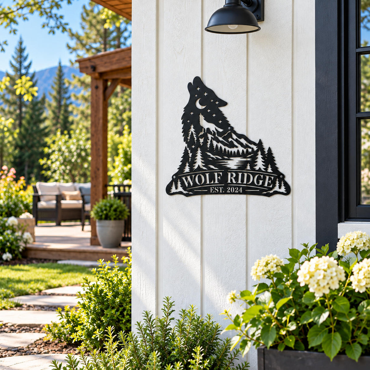 Personalized black wolf metal wall decor mounted on a light-colored exterior wall surrounded by garden plants.