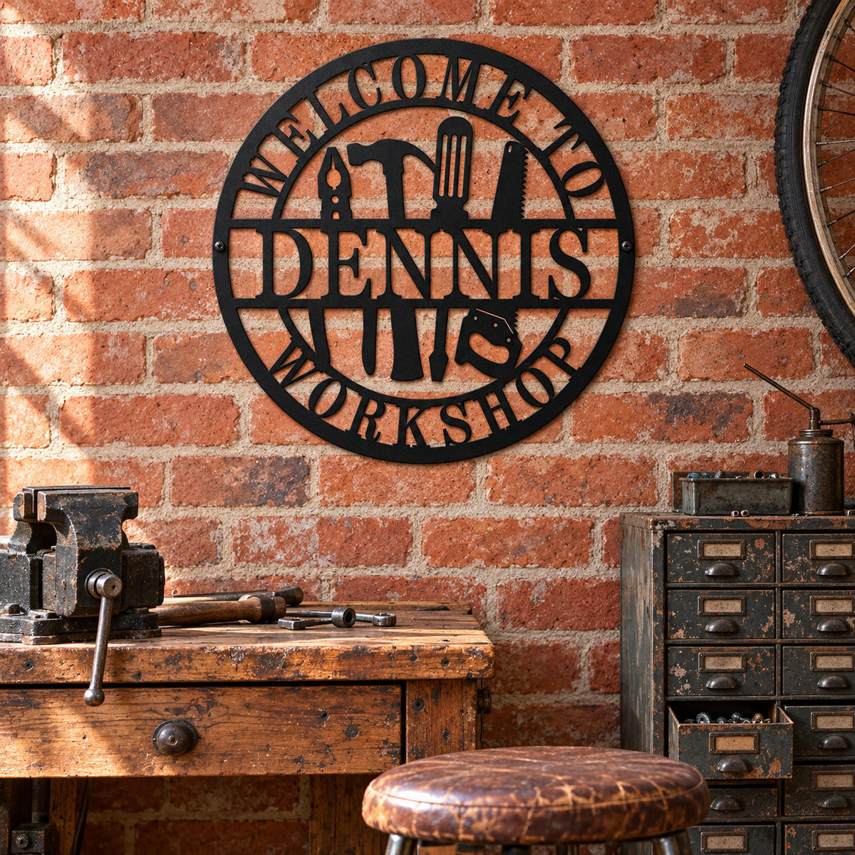 Dennis workshop metal sign on an exposed brick wall above a vintage repair bench with a vise and metal parts drawers.
