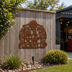 Rustic corten steel biker skull wall art mounted on a backyard fence as outdoor metal decor