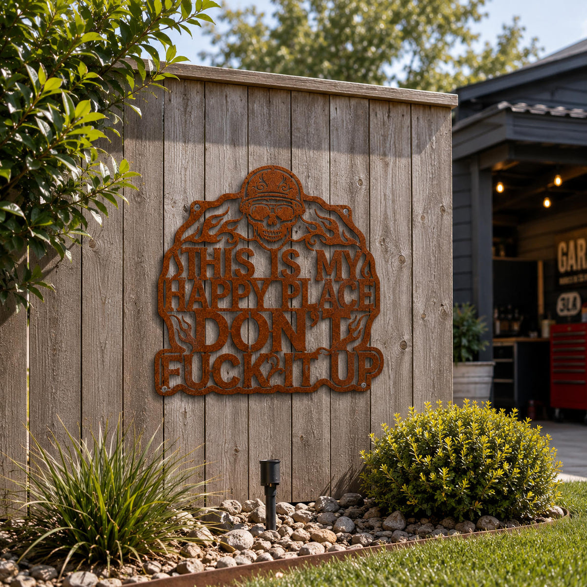 Rustic corten steel biker skull wall art mounted on a backyard fence as outdoor metal decor