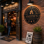 Custom Smokehouse & Grill metal sign installed at a barbecue restaurant entrance with brick wall.