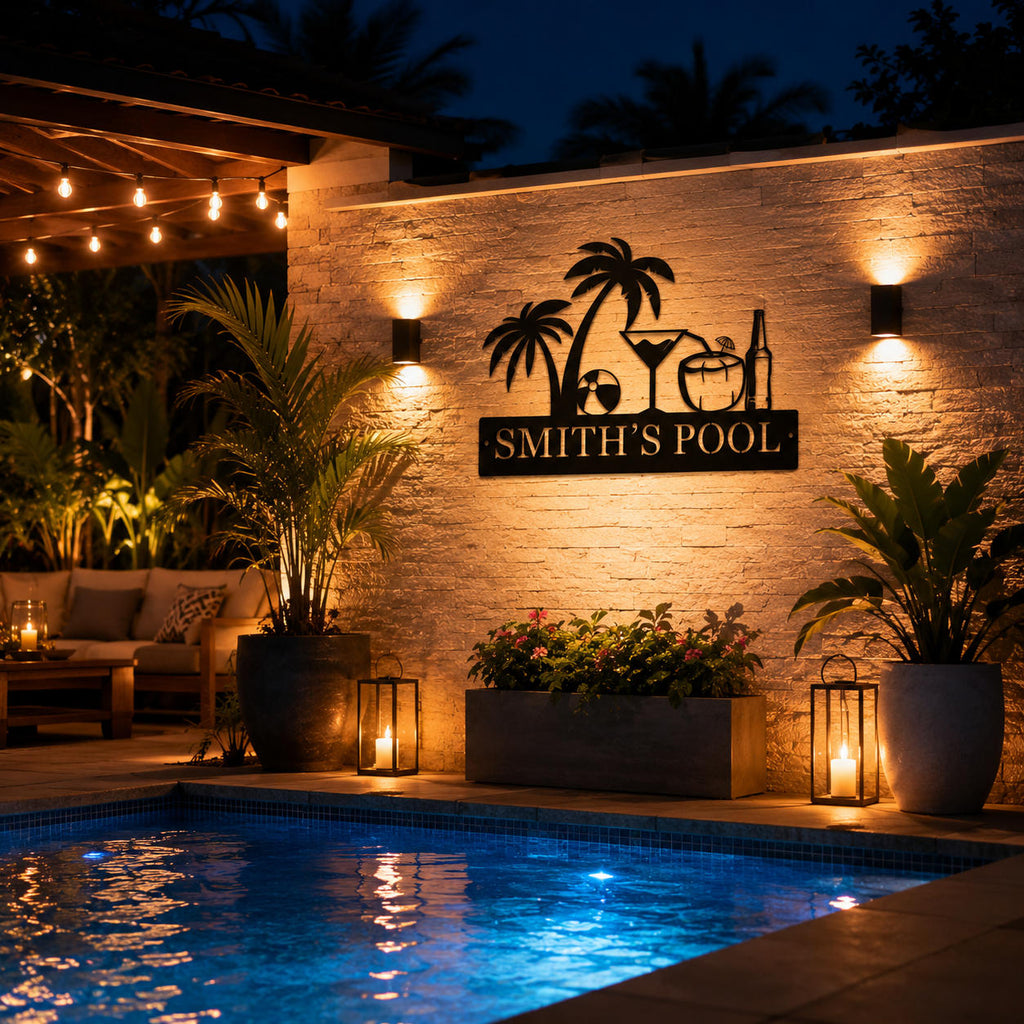 Custom steel pool sign illuminated beside a backyard swimming pool at night, personalized tropical outdoor wall decor.